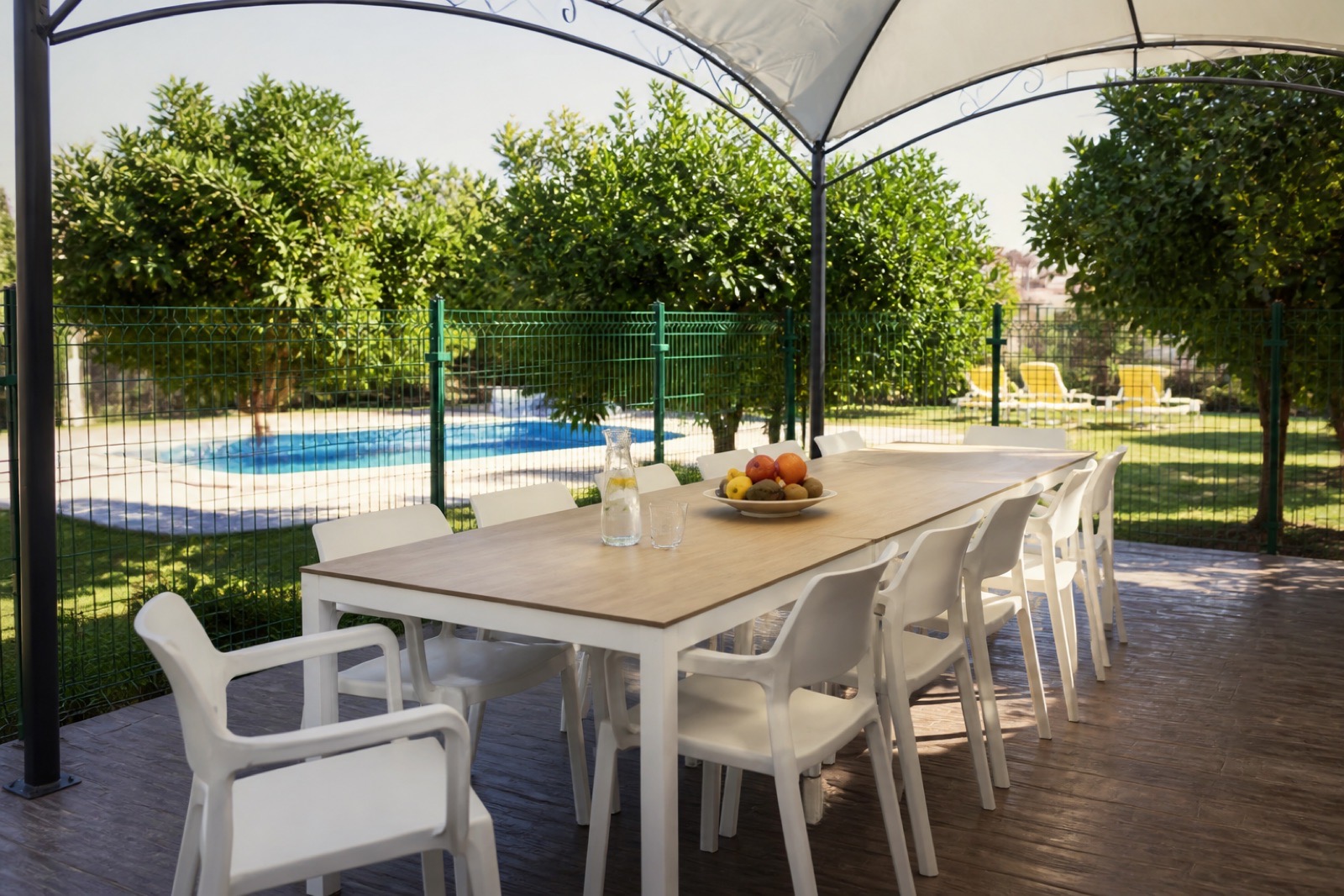 Überdachte Terrasse mit großem Tisch für gemeinsame Mahlzeiten